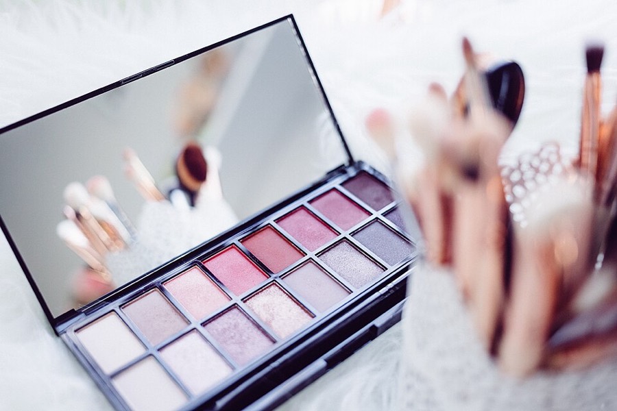 Paleta de sombras rosadas y brochas de maquillaje